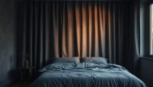 Moody bedroom with layered charcoal blackout curtains and messy linen sheets for a grunge look